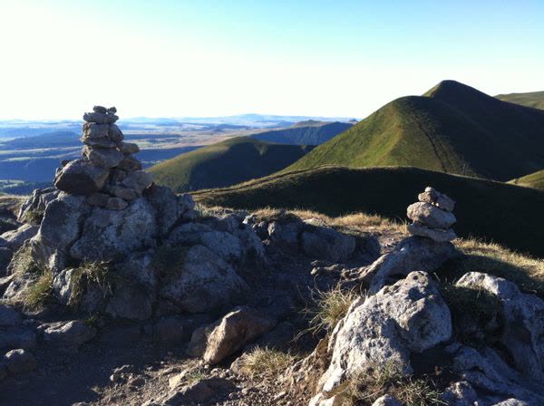 Cairns de pierres sur une crête face aux volcans d'Auvergne