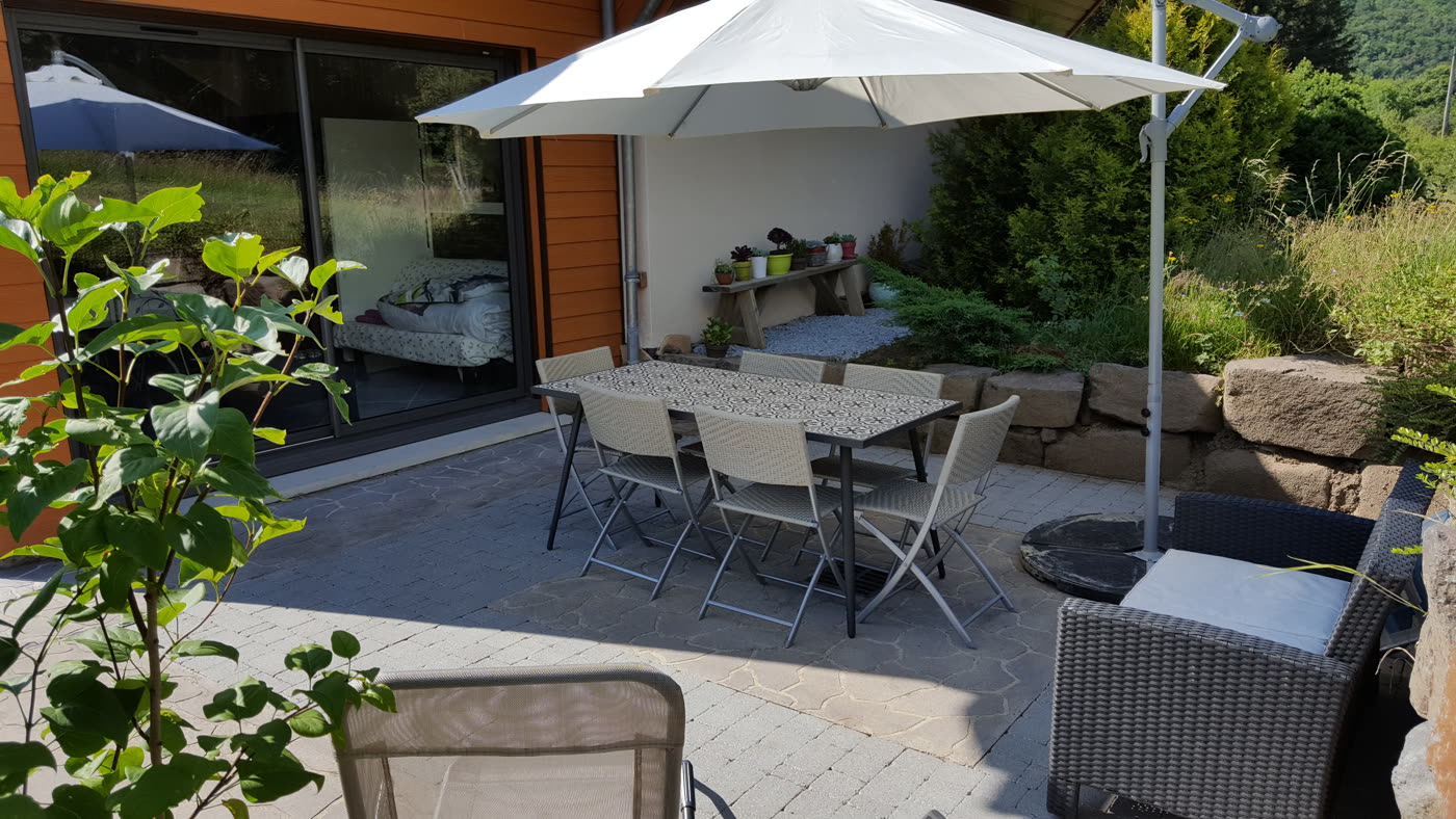 Terrasse privative avec mobilier de jardin et parasol